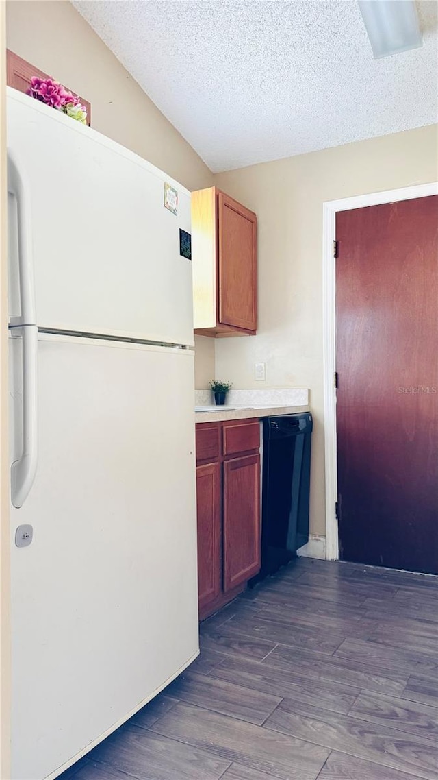 kitchen featuring a textured ceiling, white fridge, dishwasher, and dark hardwood / wood-style flooring