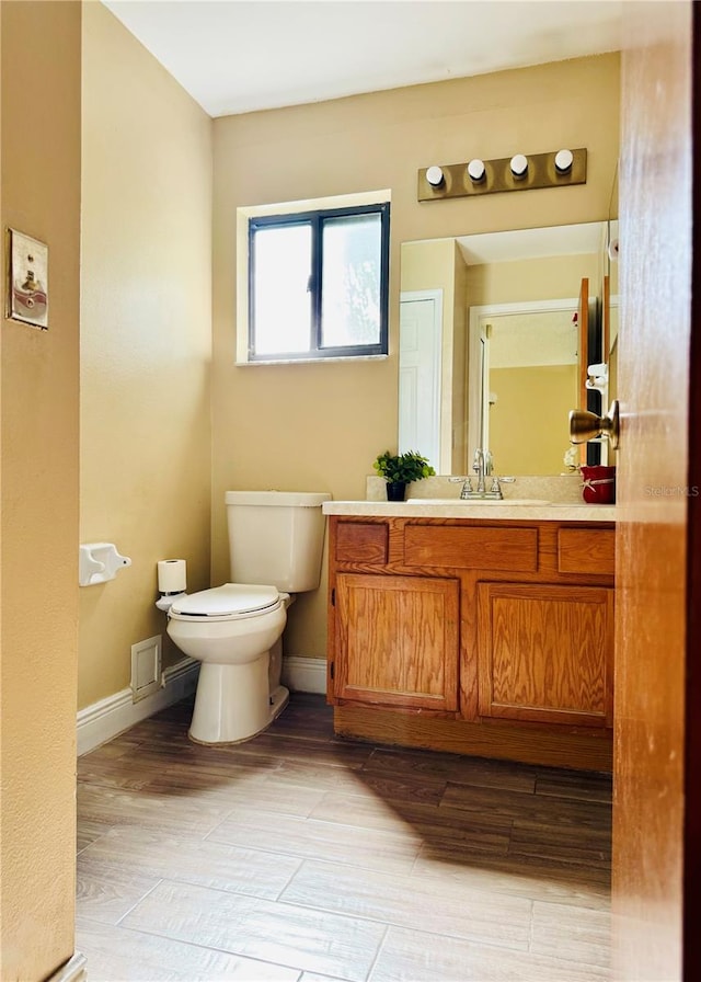 bathroom featuring vanity, hardwood / wood-style floors, and toilet