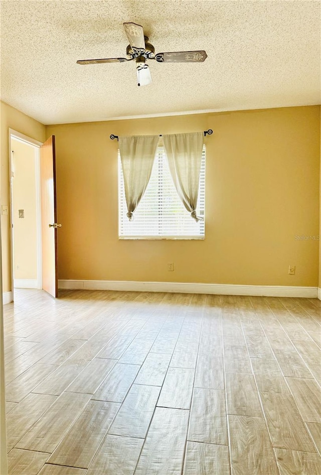 empty room featuring ceiling fan, a textured ceiling, and light wood-type flooring