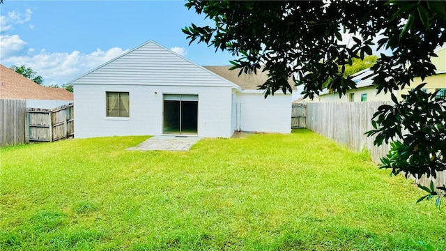 rear view of property with a yard and a patio