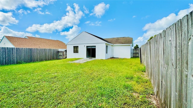 rear view of house with a patio and a yard