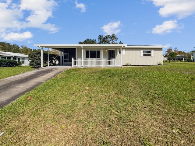 view of front of property with a porch, a front yard, and a carport