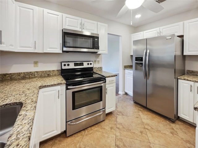 kitchen featuring ceiling fan, appliances with stainless steel finishes, white cabinetry, light tile patterned flooring, and light stone counters