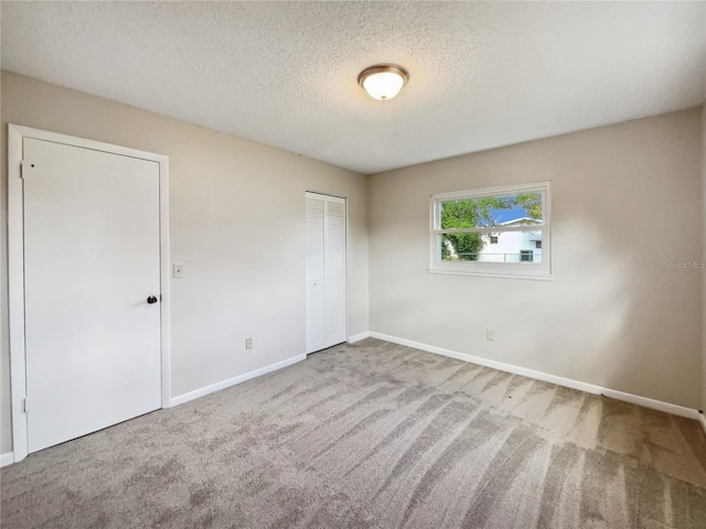 unfurnished bedroom with a closet, carpet flooring, and a textured ceiling