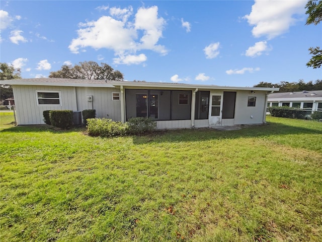 back of house featuring a yard and a sunroom