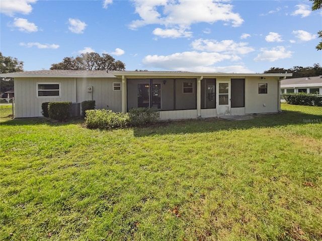 back of property featuring a yard and a sunroom