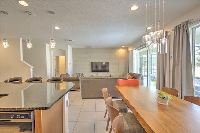 dining space featuring a textured ceiling and light tile patterned floors