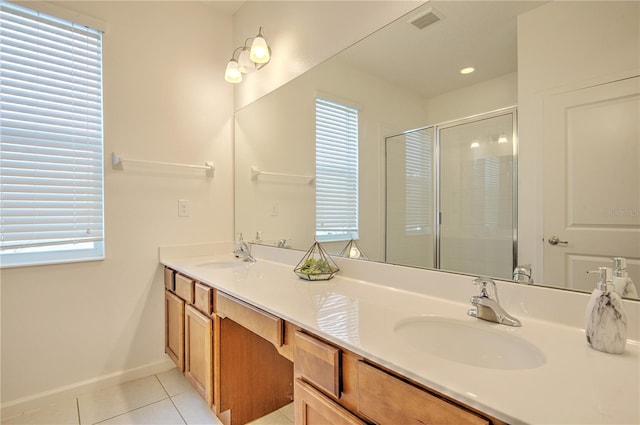 bathroom with a shower with shower door, vanity, and tile patterned flooring