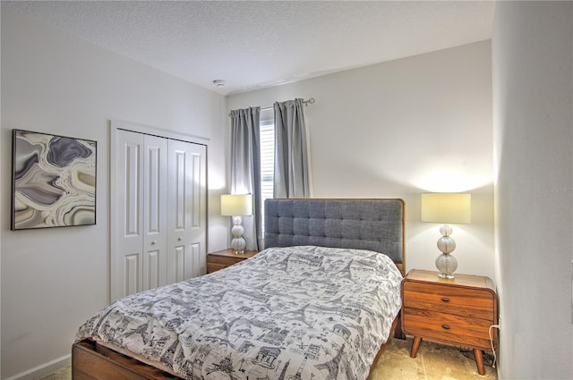 bedroom with a closet, a textured ceiling, and carpet floors