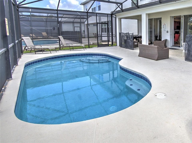 view of pool featuring glass enclosure and a patio area