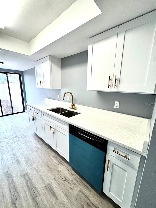 kitchen featuring white cabinets, light stone countertops, stainless steel dishwasher, light hardwood / wood-style flooring, and sink