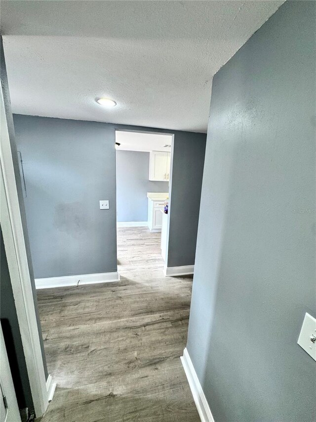 hall featuring a textured ceiling and wood-type flooring