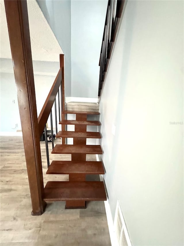 staircase with hardwood / wood-style flooring