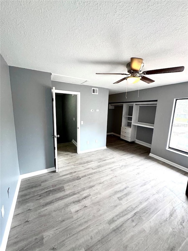 interior space featuring a closet, ceiling fan, a textured ceiling, and light hardwood / wood-style floors