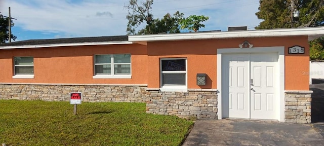 view of exterior entry with a lawn