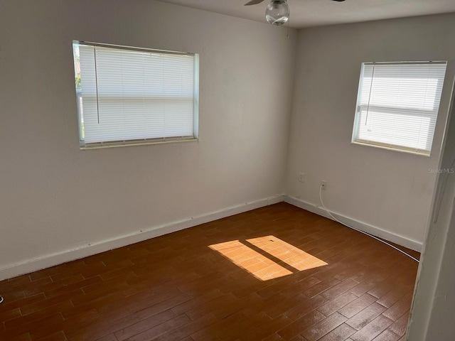 unfurnished room featuring dark wood-type flooring and ceiling fan