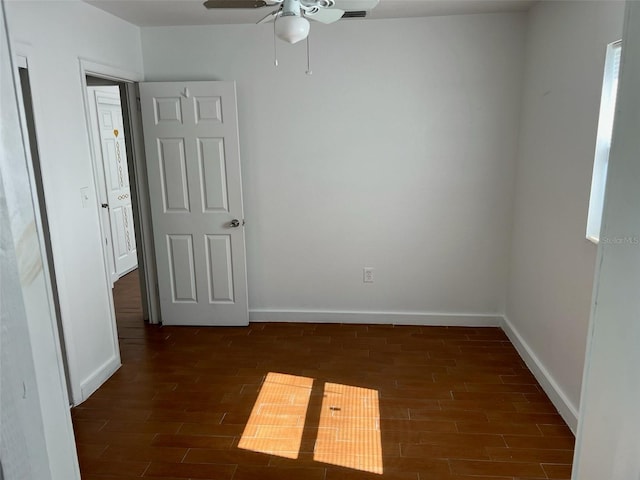 unfurnished room featuring dark wood-type flooring and ceiling fan