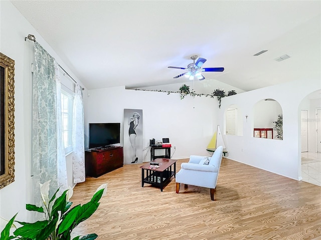 living area featuring light hardwood / wood-style floors, vaulted ceiling, and ceiling fan