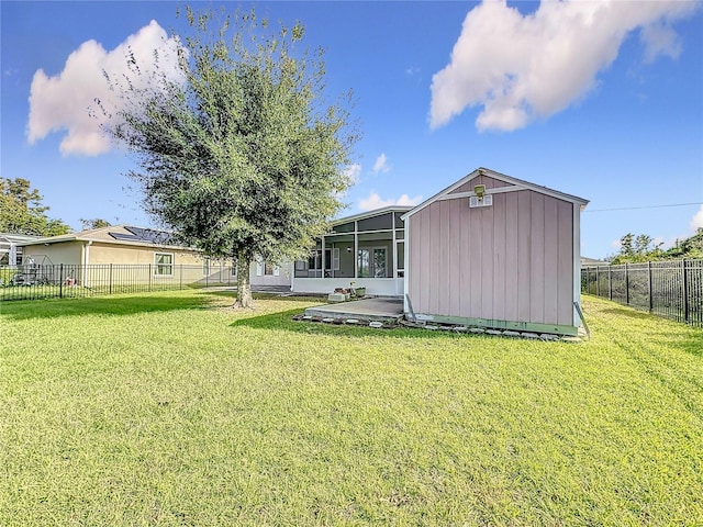 rear view of house with a shed, a patio area, and a lawn