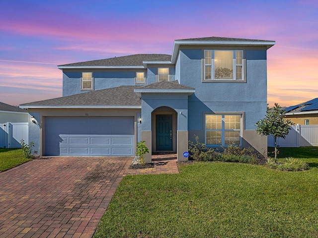 front facade with a lawn and a garage