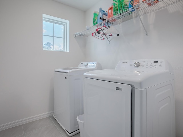 clothes washing area featuring light tile patterned floors and washing machine and clothes dryer