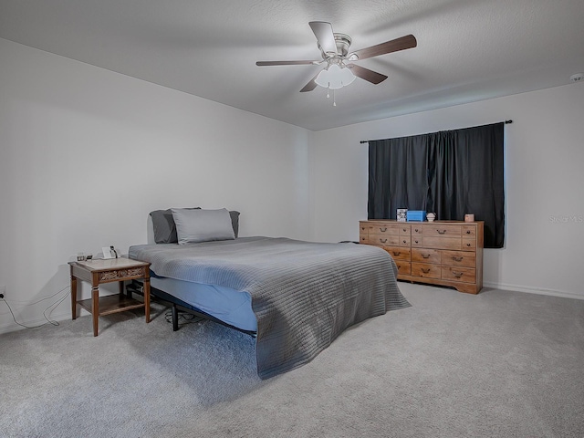 bedroom featuring carpet flooring, a textured ceiling, and ceiling fan