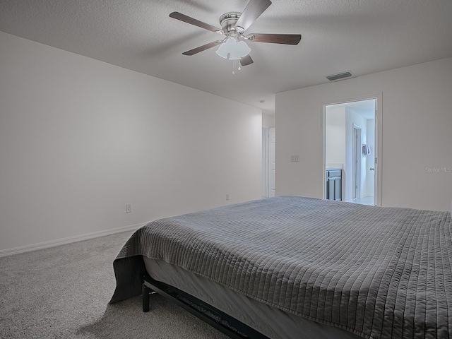 carpeted bedroom featuring ceiling fan and a textured ceiling