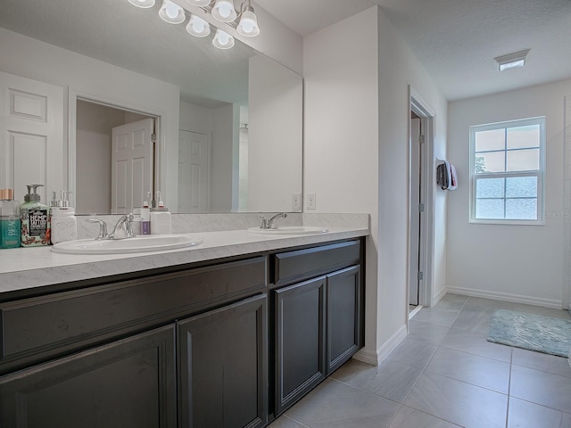 bathroom with tile patterned floors, vanity, and a textured ceiling