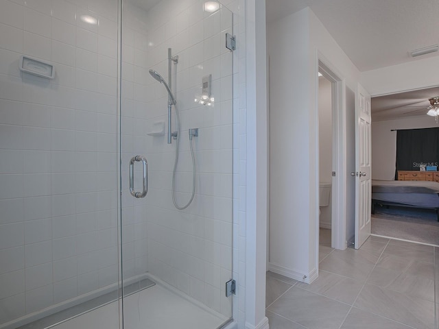 bathroom with ceiling fan, tile patterned flooring, a shower with shower door, and toilet