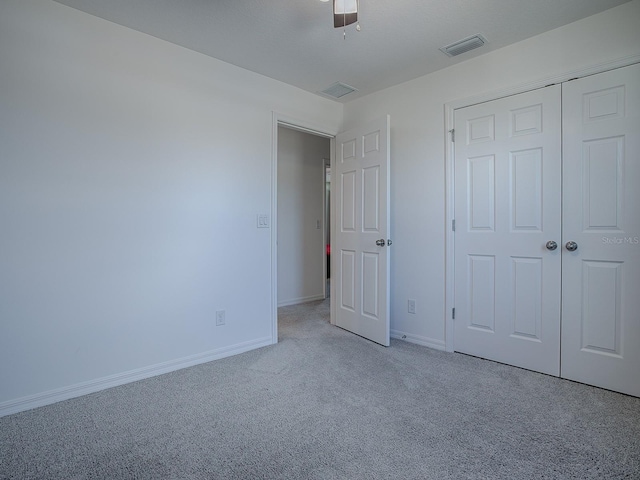 unfurnished bedroom featuring ceiling fan, a closet, and light colored carpet