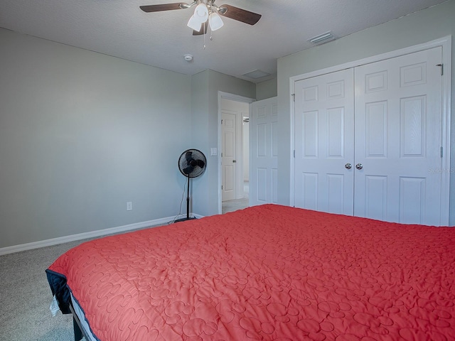 carpeted bedroom with ceiling fan, a closet, and a textured ceiling