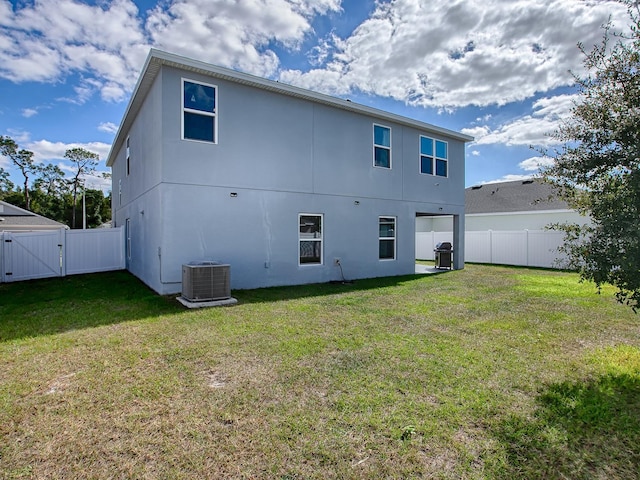 back of house with a lawn and cooling unit