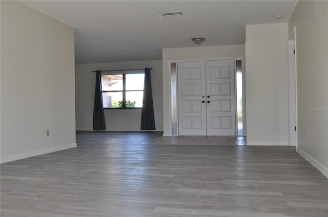 foyer featuring wood-type flooring and a textured ceiling