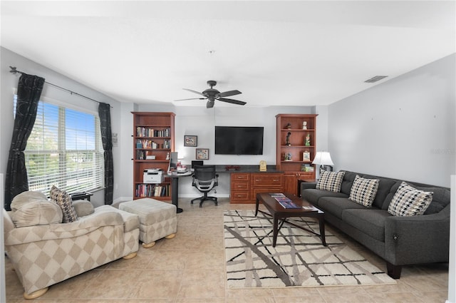 living room featuring light tile patterned floors, built in desk, and ceiling fan