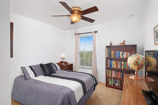 bedroom featuring ceiling fan, light colored carpet, and a textured ceiling