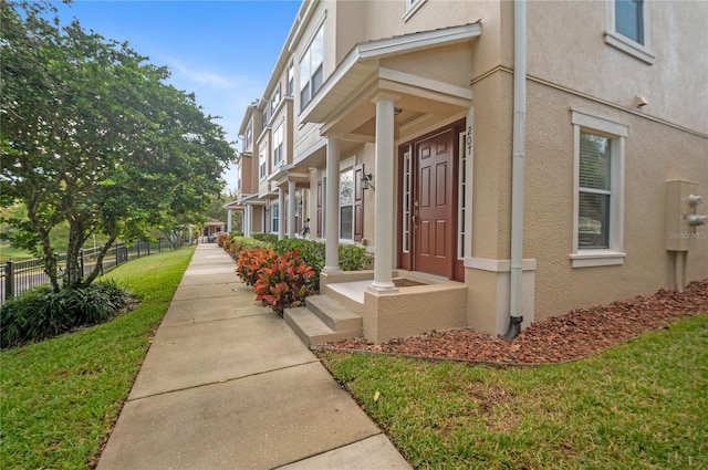 doorway to property featuring a lawn