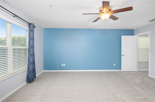 spare room featuring ceiling fan, carpet, and a textured ceiling