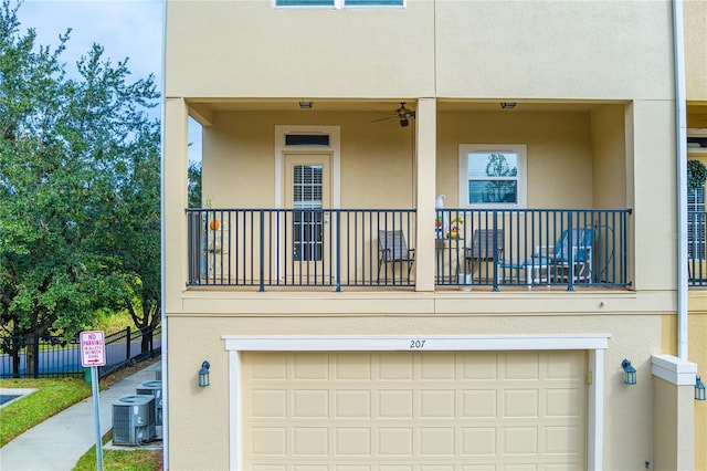 rear view of property with a garage, central AC, and a balcony