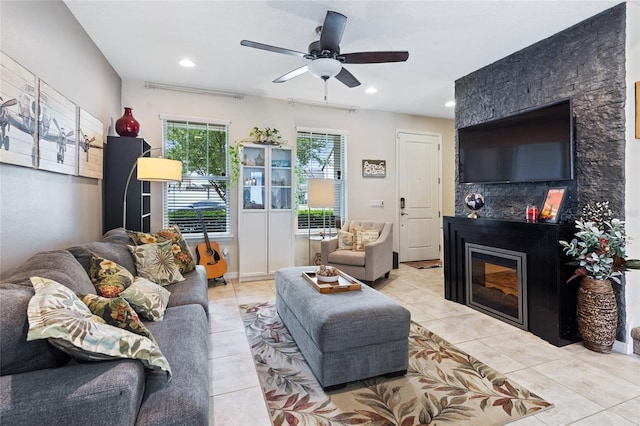 tiled living area with a glass covered fireplace, recessed lighting, and a ceiling fan