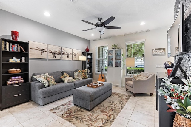 living room with a textured ceiling, light tile patterned floors, and ceiling fan