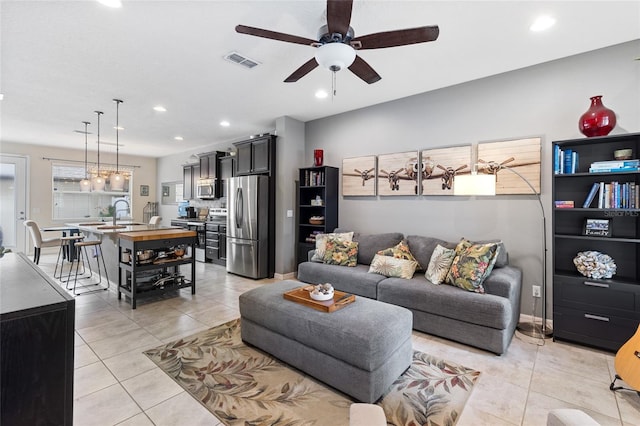 living area featuring light tile patterned flooring, a ceiling fan, and recessed lighting