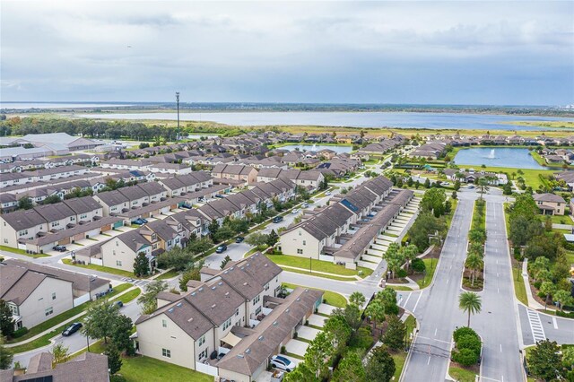 aerial view of property and surrounding area with nearby suburban area and a large body of water