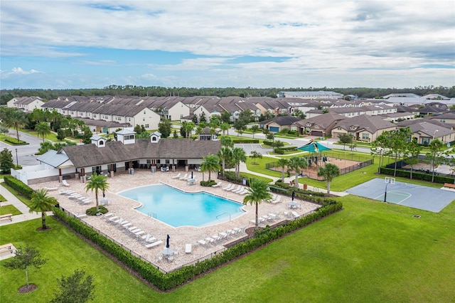 view of swimming pool with a patio, a lawn, and basketball hoop