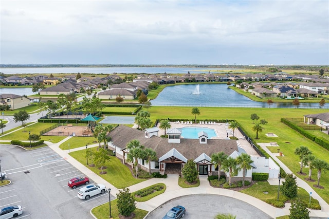 aerial view of residential area featuring a large body of water and a pool area