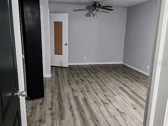 spare room with ceiling fan, a textured ceiling, and hardwood / wood-style floors