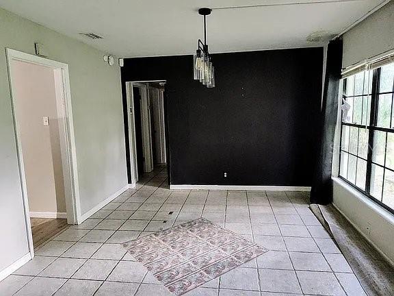 unfurnished dining area featuring light tile patterned flooring