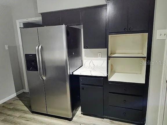 kitchen featuring stainless steel fridge and light hardwood / wood-style flooring