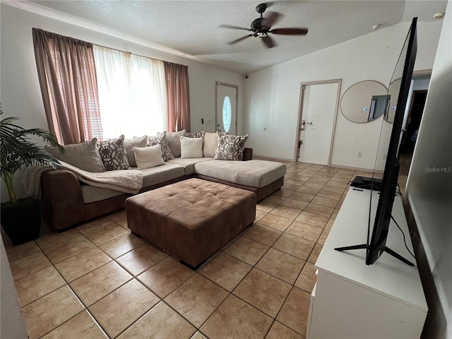 living room with lofted ceiling, ceiling fan, light tile patterned floors, and a textured ceiling