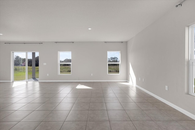 tiled empty room featuring plenty of natural light