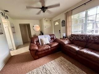 carpeted living room with ceiling fan